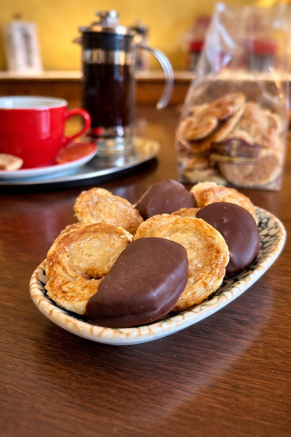 mini schweineohren mit vollmilchschokolade knuspriges blaetterteiggebaeck zum kaffee im cafe serviert